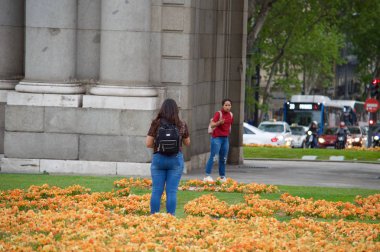 Gün batımında Puerta de Alcala'da fotoğraf çeken turistler