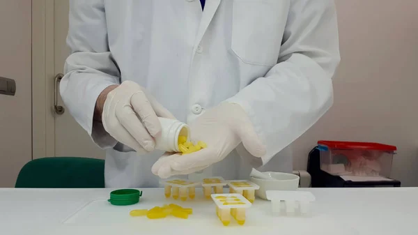 Farmácia fazendo supositórios amarelos — Fotografia de Stock