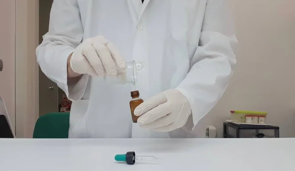 Garrafa conta-gotas manipulada por um farmacêutico — Fotografia de Stock