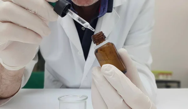 Bir eczacı tarafından manipüle damlalık şişe 