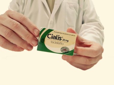Pharmacist showing a box of Cialis  clipart