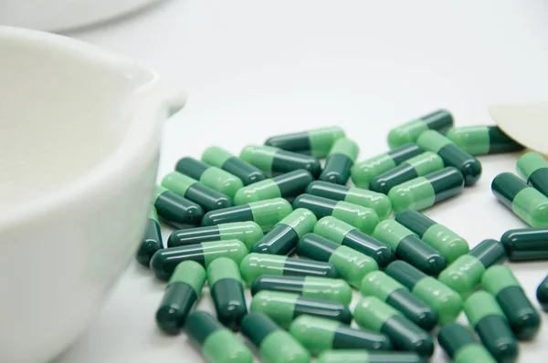 Green capsules in the pharmacy laboratory
