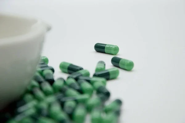 Green capsules in the pharmacy laboratory