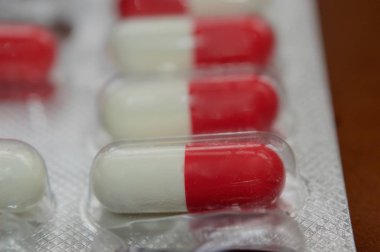 Makro görünümde ilaç kapsülleri ve koyu kahverengi arkaplan