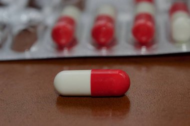 Makro görünümde ilaç kapsülleri ve koyu kahverengi arkaplan