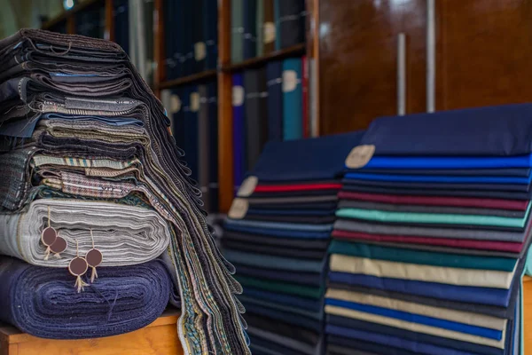 Photo of Rolls of textiles in a fabric shop. Multi colors and patterns.