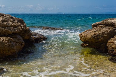 Murter, Hırvatistan, Dalmaçya'da taşlı bir plajda dalgalar kırılıyor