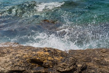 Murter, Hırvatistan, Dalmaçya'da taşlı bir plajda dalgalar kırılıyor
