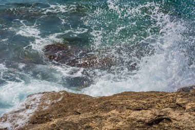 Murter, Hırvatistan, Dalmaçya'da taşlı bir plajda dalgalar kırılıyor