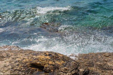 Murter, Hırvatistan, Dalmaçya'da taşlı bir plajda dalgalar kırılıyor