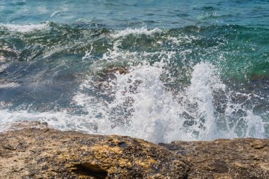 Murter, Hırvatistan, Dalmaçya'da taşlı bir plajda dalgalar kırılıyor