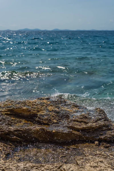 Onde che si infrangono su una spiaggia rocciosa a Murter, Croazia, Dalmazia — Foto Stock