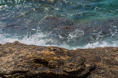 Murter, Hırvatistan, Dalmaçya'da taşlı bir plajda dalgalar kırılıyor