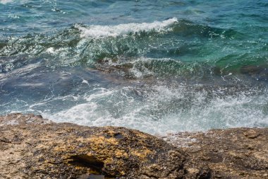 Murter, Hırvatistan, Dalmaçya'da taşlı bir plajda dalgalar kırılıyor