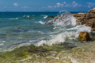 Murter, Hırvatistan, Dalmaçya'da taşlı bir plajda dalgalar kırılıyor