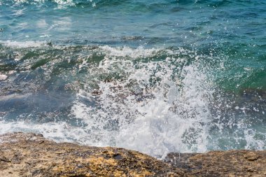 Murter, Hırvatistan, Dalmaçya'da taşlı bir plajda dalgalar kırılıyor