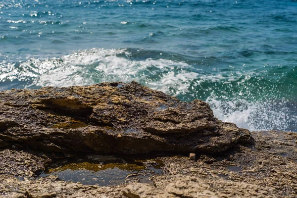 Murter, Hırvatistan, Dalmaçya'da taşlı bir plajda dalgalar kırılıyor