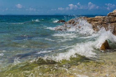 Murter, Hırvatistan, Dalmaçya'da taşlı bir plajda dalgalar kırılıyor