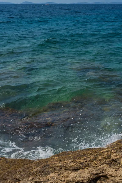 Wellen brechen an einem steinigen Strand in Murter, Kroatien, Dalmatien — Stockfoto