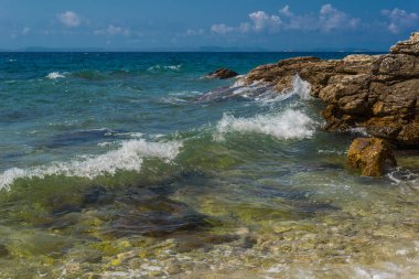 Murter, Hırvatistan, Dalmaçya'da taşlı bir plajda dalgalar kırılıyor