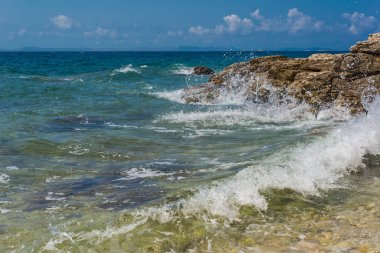 Murter, Hırvatistan, Dalmaçya'da taşlı bir plajda dalgalar kırılıyor