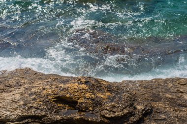 Murter, Hırvatistan, Dalmaçya'da taşlı bir plajda dalgalar kırılıyor