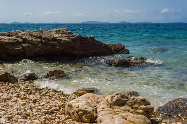 Wellen brechen an einem steinigen Strand in Murter, Kroatien, Dalmatien — Stockfoto