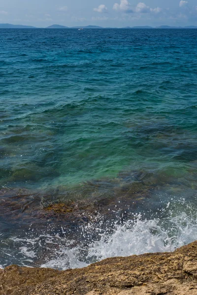 Wellen brechen an einem steinigen Strand in Murter, Kroatien, Dalmatien — Stockfoto