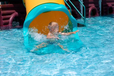 Mutlu küçük çocuk Aquapark 'ta havuzda oynuyor.