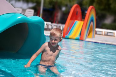 Mutlu küçük çocuk Aquapark 'ta havuzda oynuyor.