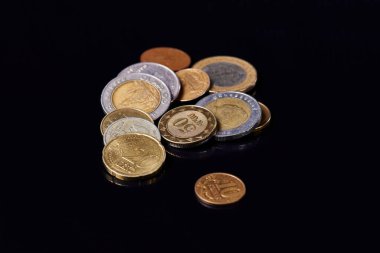 Farklı ülkelerin bozuk paraları, siyah camlar üzerinde.