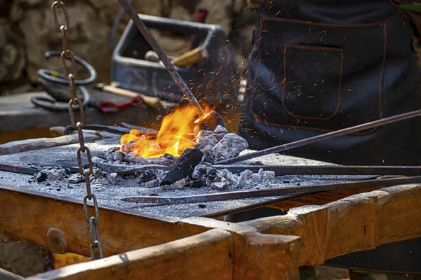El herrero calentando el metal en el fuego — Foto de Stock