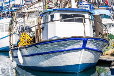 Balıkçı teknesi limanda palamarla güvertede olta takımı ile