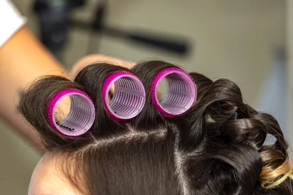 Woman head with hair curled on large curlers