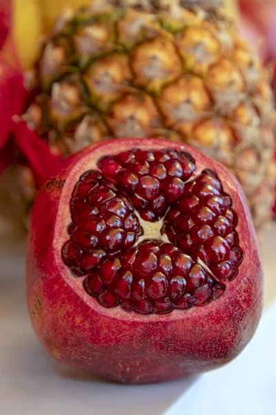 Abra la fruta de granada de cerca sobre un fondo borroso de piña — Foto de Stock