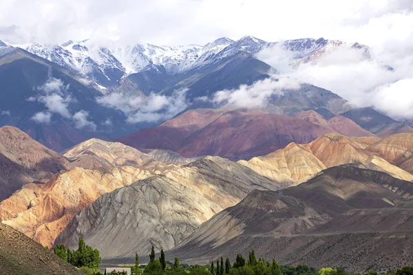 Vista das montanhas coloridas e picos cobertos de neve com nuvens sobre eles. Viagem Quirguistão — Fotografia de Stock