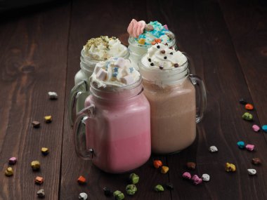 Ahşap masada lezzetli kokteyller ve tatlılar