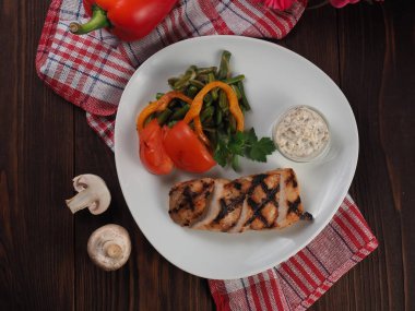 Bir tabakta ızgara biftek dilimlenmiş parçalar ve sebzeler