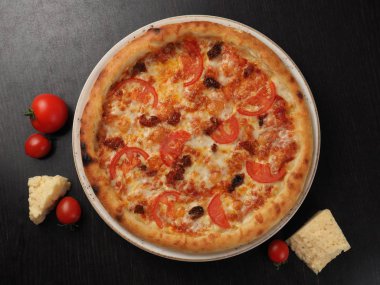 Bir tabakta domates ve peynir ile Pizza