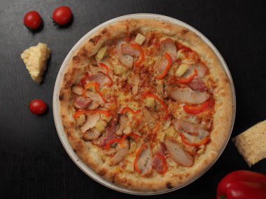 Bir tabaktabakta jambon, tavuk, biber ve peynir ile Pizza