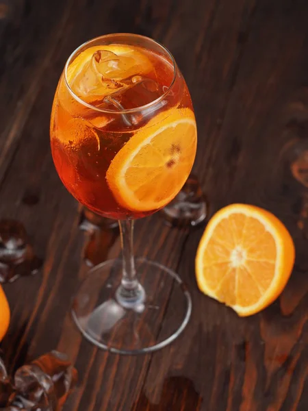 Orange cocktail with ice in a glass on a wooden surface — Stock Photo, Image