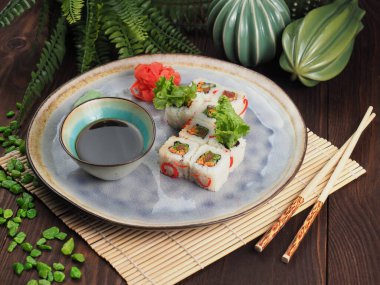 Ahşap masa, halı, yemek çubukları ve bir tabak ekmek.