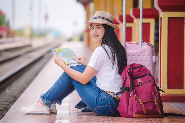 Young asian gril walking at train station before travel. work and travel concept.