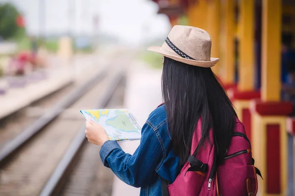 Young asian gril walking at train station before travel. work and travel concept.