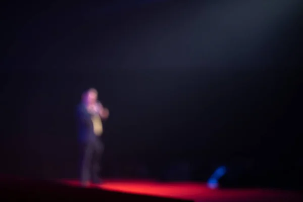 Blurred background of speaker on stage in seminar room