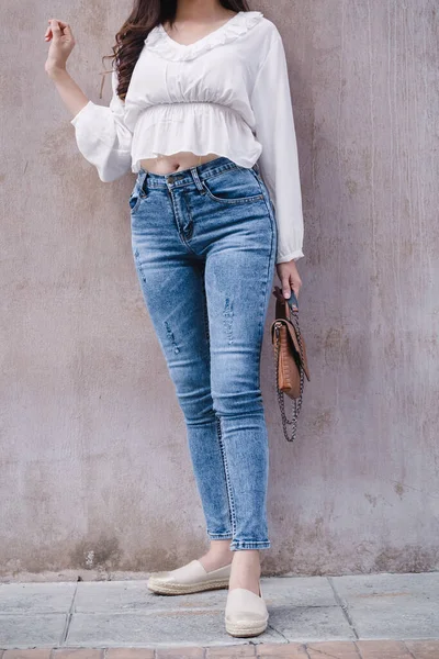 Happy Asia woman in bright blue skinny crop jeans, sky blue jeans