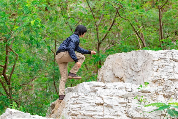 Man wearing cargo pants and climbing on the rock