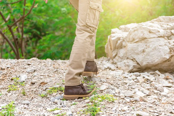 Man wearing cargo pants and climbing on the rock