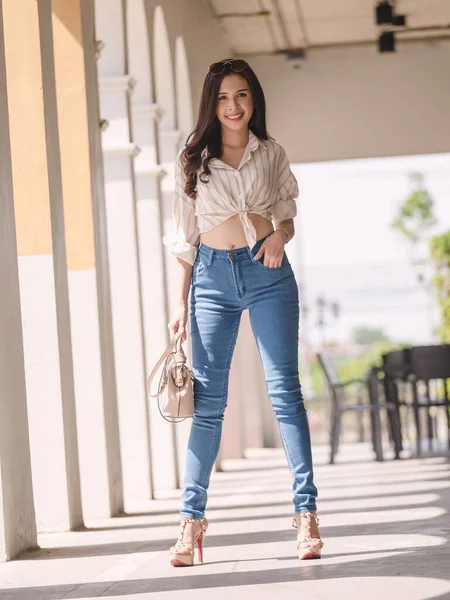 Happy Asia woman in bright skinny jeans, sky blue jeans