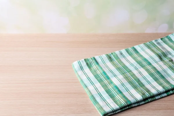 green table cloth on wood table in front of the tropical beach